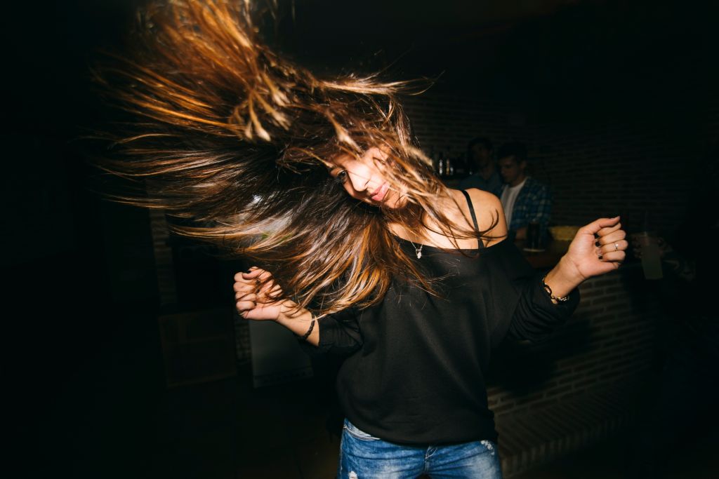 Woman tossing her hair and dancing in nightclub