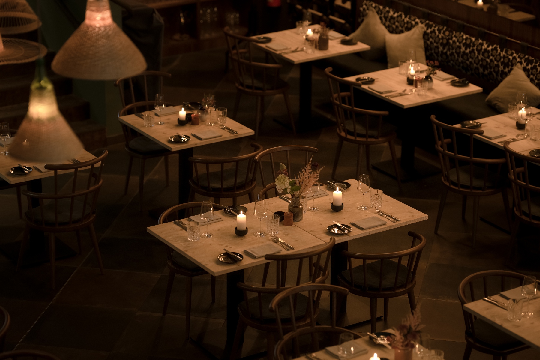 Restaurant mit gedämmten Licht und unterschiedlichsten Tischen – ©KITCHENS